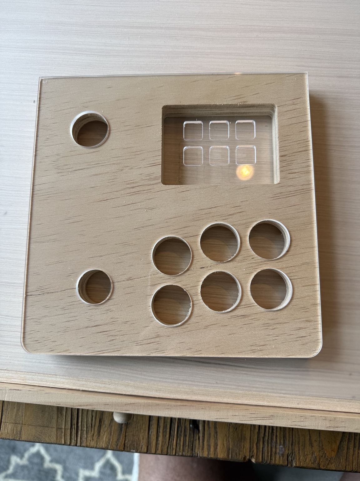 My fabricated test panel with clear plexiglass aligned over plywood, circular control openings and six key apertures above one rectangular wood opening