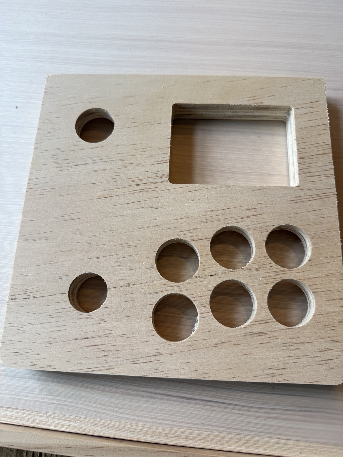 CNC-cut plywood top with start and joystick holes, six action-button holes and a rectangular device opening