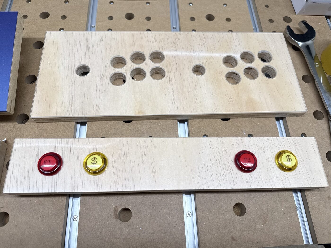 Clear plexiglass overlay aligned over the wood control panel beside a front-panel button fit check