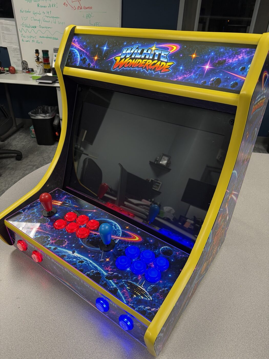 Finished bartop arcade close-up with red and blue illuminated buttons, galaxy vinyl, and yellow trim